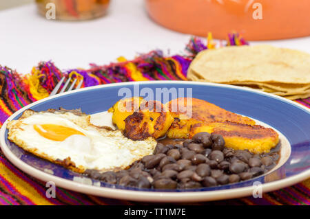 Mexican tropical breakfast, made with plantains, eggs and black beans with tortillas, copy space Stock Photo