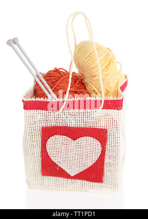 Woolen balls of yarn and wooden knitting needles in rustic craft bag, isolated on white Stock Photo