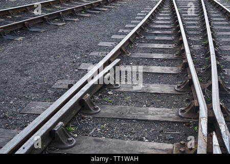 Perspective view of lines of hot rolled steel railway tracks, links, fasteners, sleepers and ballast at Didcot Railway Centre, Oxfordshire, UK. Stock Photo