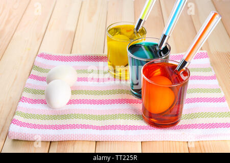 Glasses with paint for Easter eggs and eggs, close up Stock Photo