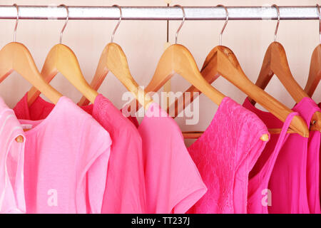 Female clothes on hangers in wardrobe Stock Photo