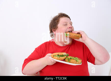 Fat man eating tasty sandwich  isolated on white Stock Photo