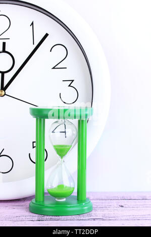 Hourglass and big clock on light background Stock Photo