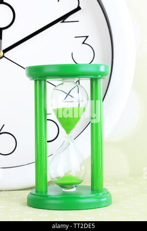 Hourglass and big clock on light background Stock Photo