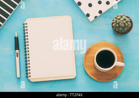Open notebook with empty pages and other office supplies over blue office desk table. Top view Stock Photo