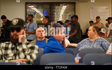 Wethersfield, CT / USA - June 11, 2019: Snapshot of a bored crowd of people in the waiting area (focus on those standing in line) Stock Photo