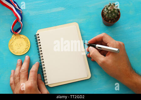 Open notebook with empty pages and other office supplies over blue office desk table. Top view Stock Photo