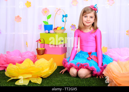 Beautiful small girl in petty skirt on decorative background Stock Photo