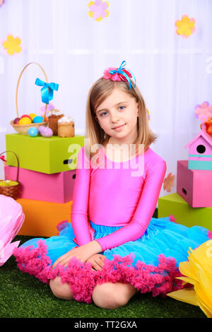 Beautiful small girl in petty skirt on decorative background Stock Photo