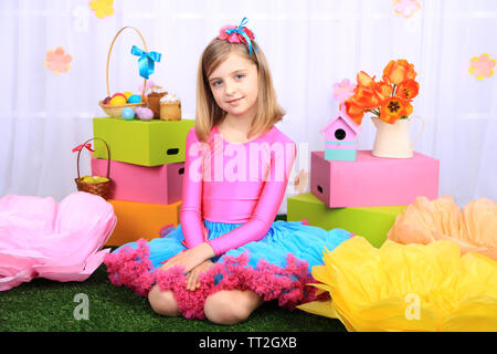 Beautiful small girl in petty skirt on decorative background Stock Photo