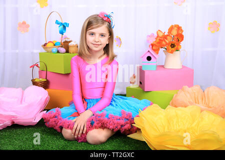 Beautiful small girl in petty skirt on decorative background Stock Photo