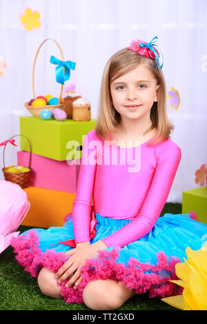 Beautiful small girl in petty skirt on decorative background Stock Photo