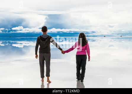 Uyuni, Bolivia- Dec 31, 2018: Man and woman walking away on the lake Salar de Uyuni, Bolivia. America. Stock Photo