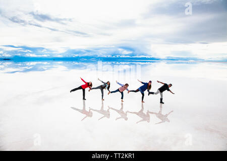 Uyuni, Bolivia- Dec 31, 2018: Group of people make figures with their bodies on the lake Salar de Uyuni, Bolivia. America Stock Photo