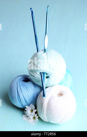 Colorful clews and crochet hooks on wooden background Stock Photo