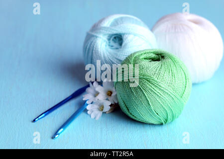 Colorful clews and crochet hooks on wooden background Stock Photo