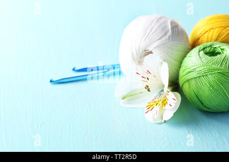 Colorful clews and crochet hooks on wooden background Stock Photo