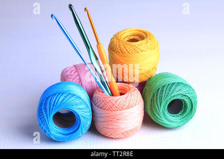 Colorful clews and crochet hooks on light background Stock Photo