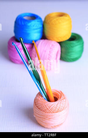Colorful clews and crochet hooks on light background Stock Photo