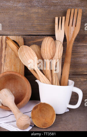 Composition of wooden cutlery, mortar, bowl and cutting board on wooden background Stock Photo