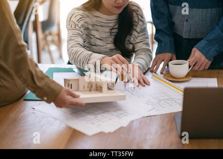Group of an architect working and measuring scale of a mass model on table in office Stock Photo