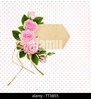 Pink rose flowers with raffia bow in a floral arrangement on craft paper label Stock Photo