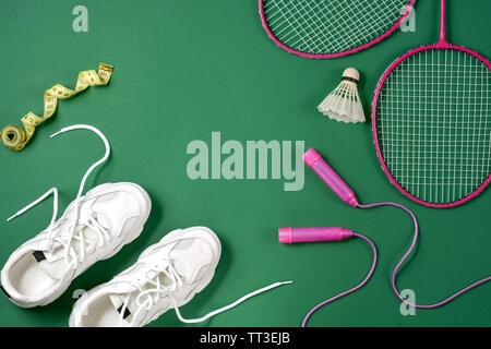 Sports equipment.. Shuttlecock and badminton racket, skipping rope, sneakers  and measuring tape on green background. Fitness, sport and healthy lifest  Stock Photo - Alamy