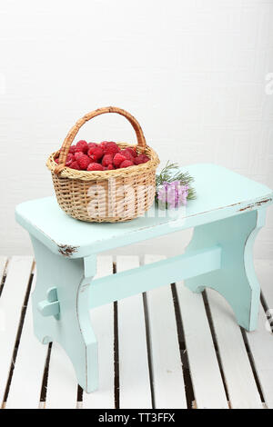 Fresh raspberries in basket on white wall background Stock Photo