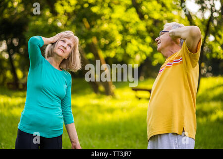 Senior couple is exercising in park. Stock Photo