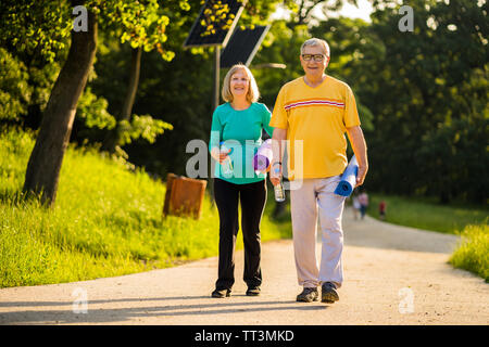 Happy senior couple is going to exercise in park. Stock Photo