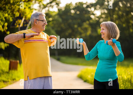 Senior couple is exercising in park. Stock Photo