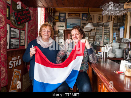 Crosshaven, Cork, Ireland. 14th June, 2019. Thecla and Joleen Cronin getting ready for the arrival of King Willem-Alexander and Queen Máxima of the Netherlands when they will visit their bar during the Royal visit to Crosshaven, Co. Cork, Ireland. Credit: David Creedon/Alamy Live News Stock Photo