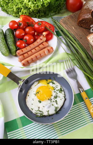 Scrambled egg with sausage and vegetables served on pan on cutting board Stock Photo