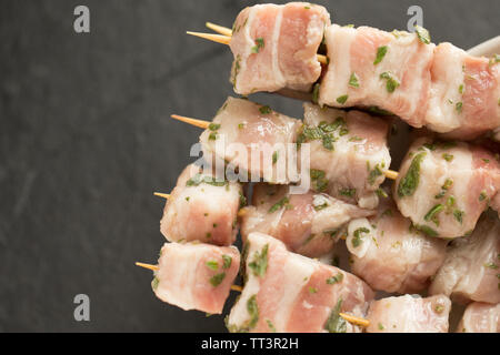 Raw, cubed British belly pork bought from a supermarket in the UK that has been marinated in lemon juice and fresh, chopped marjoram ready to be grill Stock Photo