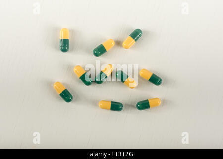 Green, yellow tramadol capsule pills on white background.Pain killer capsules called 'Tramadol HCL'.The medicine for pain relive. Stock Photo
