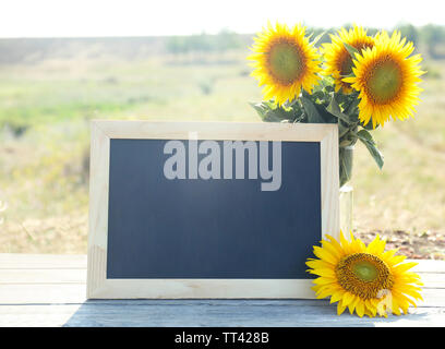 Beautiful sunflowers blackboard blank on wooden background Stock Photo