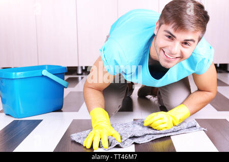 Young man cleaning floor in room Stock Photo