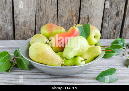 Pear fruits in the old aluminum plates on wooden background Stock Photo