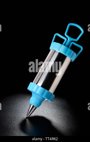 Icing pen on black grained surface of the table Stock Photo