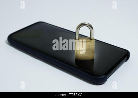 Conceptual photo security on mobile phones. A closed padlock on a cell phone on a white background. Stock Photo