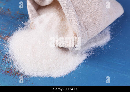 Sugar in bag on color wooden background Stock Photo