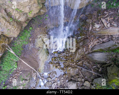 The place of falling of a waterfall among the rocks in the forest. Top view. Stock Photo