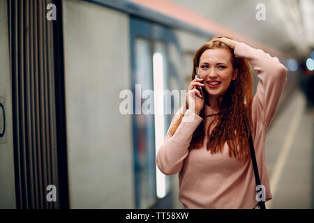Positive redhead young female portrait. Moscow metro. Stock Photo