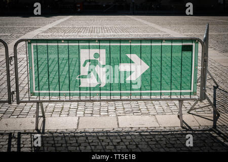 emergency exit sign on security fence for - Stock Photo