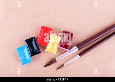 Watercolor paint cubes and brushes on beige background Stock Photo