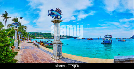 PHIPHI DON, THAILAND - APRIL 27, 2019: The scenic seaside promenade of Phi Phi Done Island with tall columns, decorated with sculptures of marlin fish Stock Photo