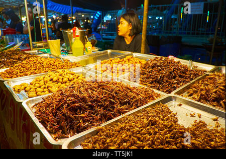 AO NANG, THAILAND - APRIL 27, 2019: The stall of Ao Nang Night Bazaar with extreme snacks - fried bamboo worms, crickets, grasshoppers, water bugs and Stock Photo