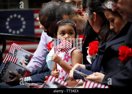 Philadelphia, PA, USA - June 14, 2019: The daughter of a immigrant holds an American flag while she joins her mother's naturalization ceremony on Flag Day at the historic Betsy Ross House in Philadelphia, Pennsylvania. Credit: OOgImages/Alamy Live News Stock Photo