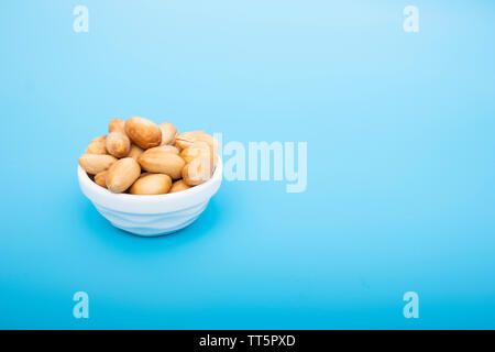 Roasted peanuts isolated on blue surface Stock Photo