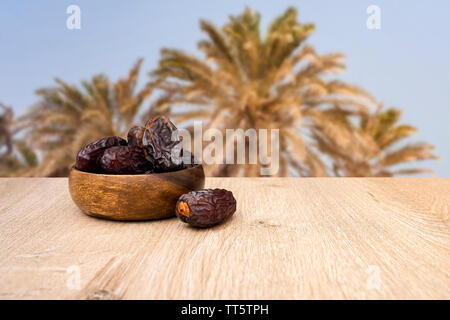 Dates fruit in bowl, background is date fruit tree Stock Photo